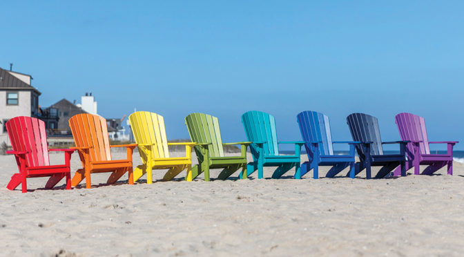 Fanback chairs in bright colors on a beach.