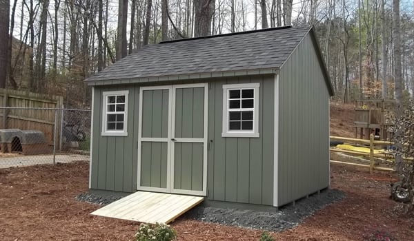 Shed set on prepared site in a backyard.