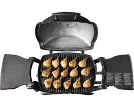 Q 1200 Gas Grill - Black, with chicken wings on it.