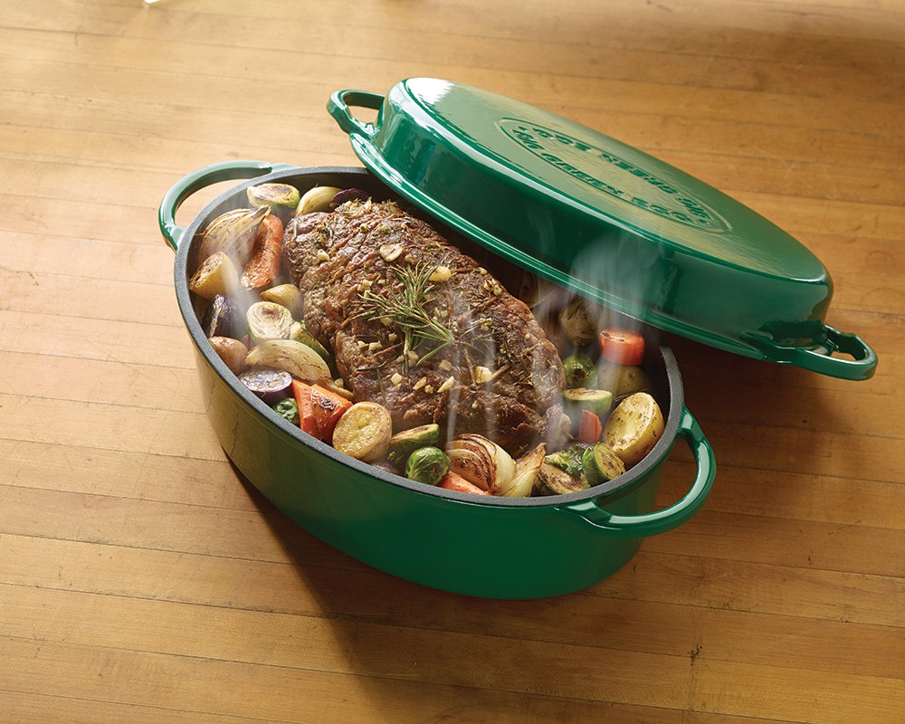 Big Green Egg enameled round dutch oven with roast beef and vegetables.