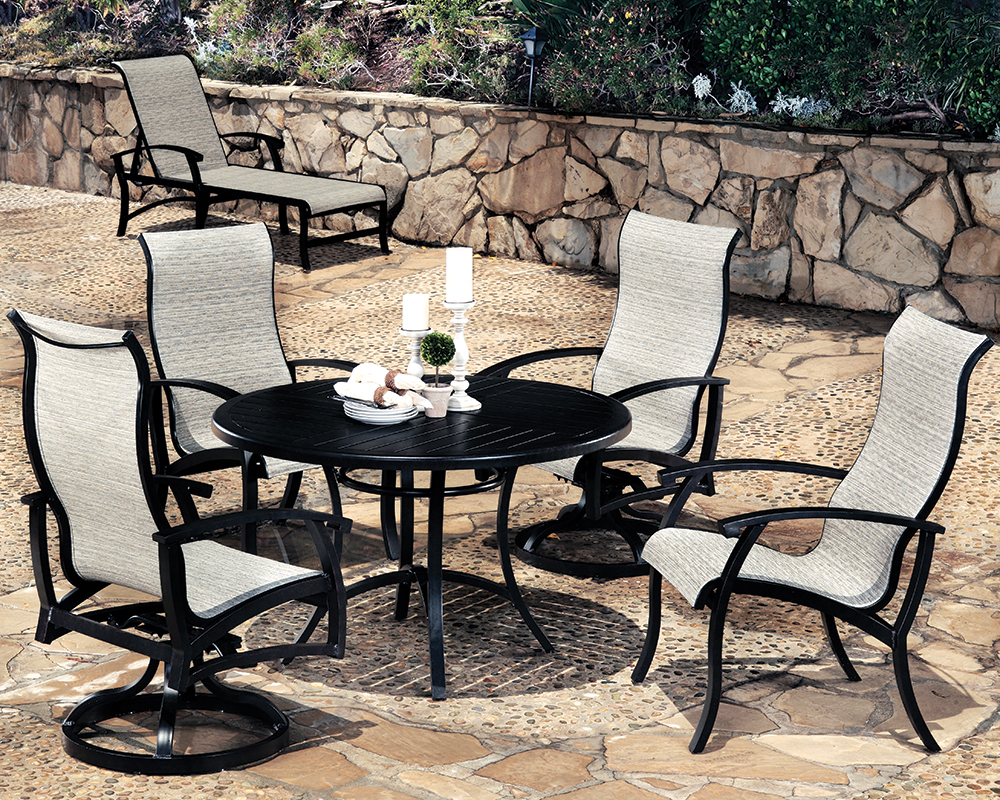 Georgetown Sling Chair Dining Set on Patio with Sling Chaise Lounge in the Background.