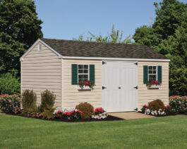 10x16 Vinyl A-Frame Shed in Cream Siding, White Trim, Green Shutters, and Brownstone Shingles with summer flowers.