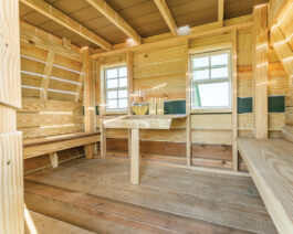 Wooden Scout camper playset, inside view of benches and table.